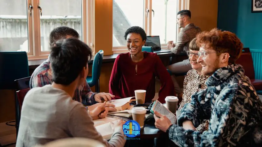 a group of people sitting at a table in a coffee shop