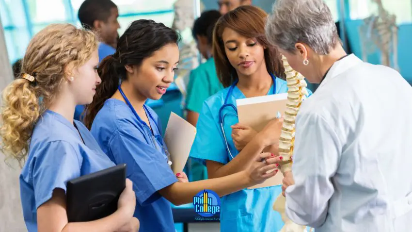 a group of people in scrubs looking at a spine