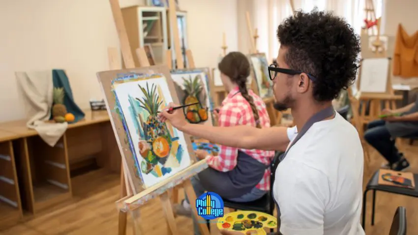 a person is painting on an easel in an art class