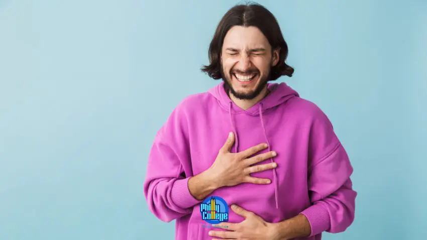 a person in a purple sweatshirt is holding their stomach