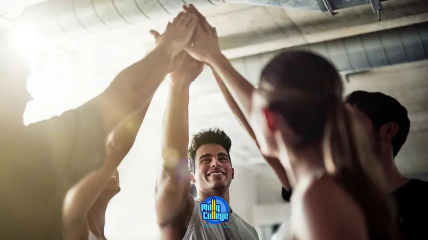 a group of people high fiving each other in a gym