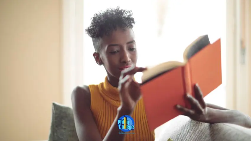 A person reading a book while sitting on a couch
