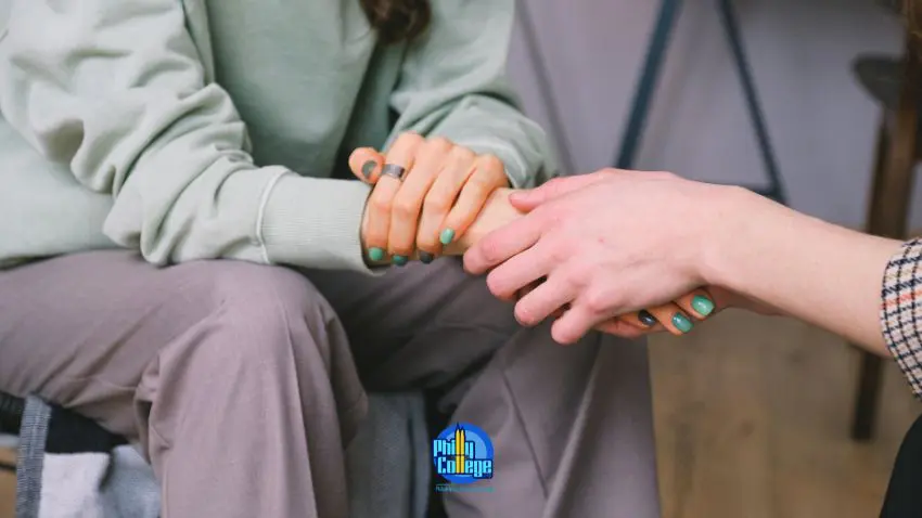 two people holding hands while sitting on a couch