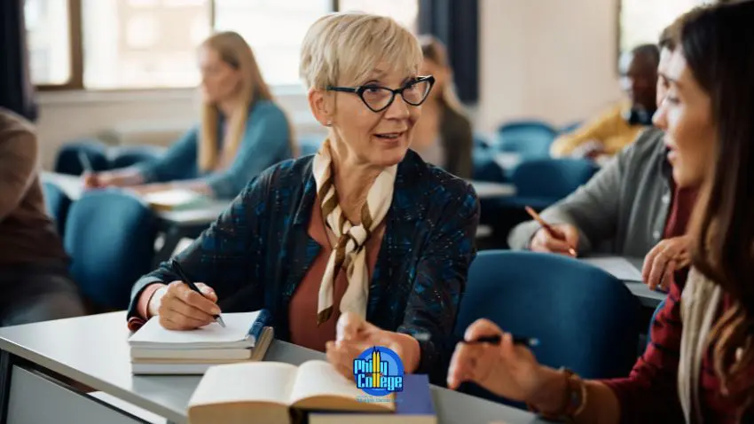 A person sitting at a desk in front of a group of students