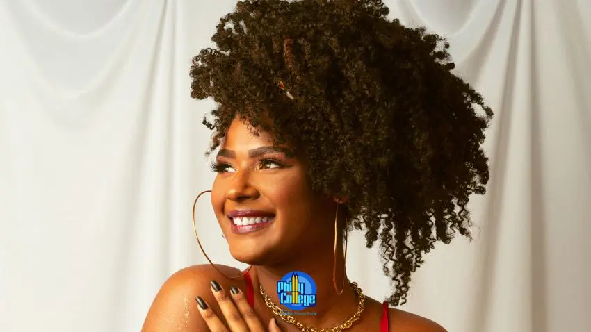 a person with curly hair wearing a red dress