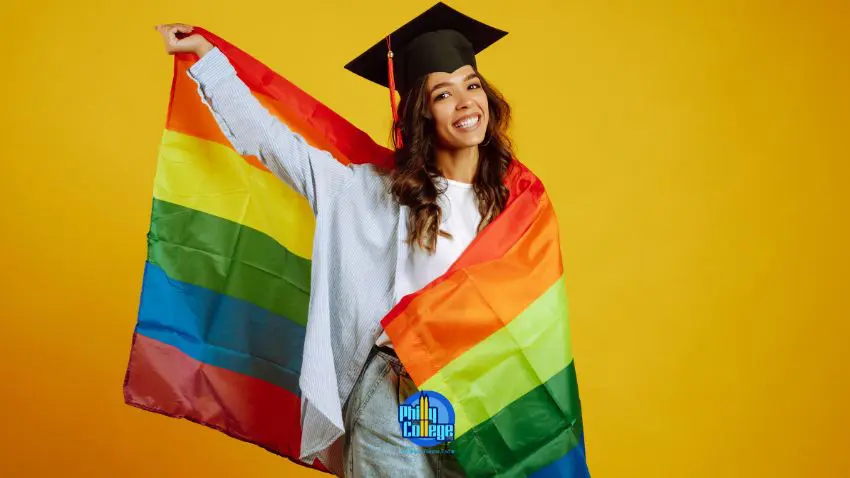 a person in a graduation cap and gown holding a rainbow flag