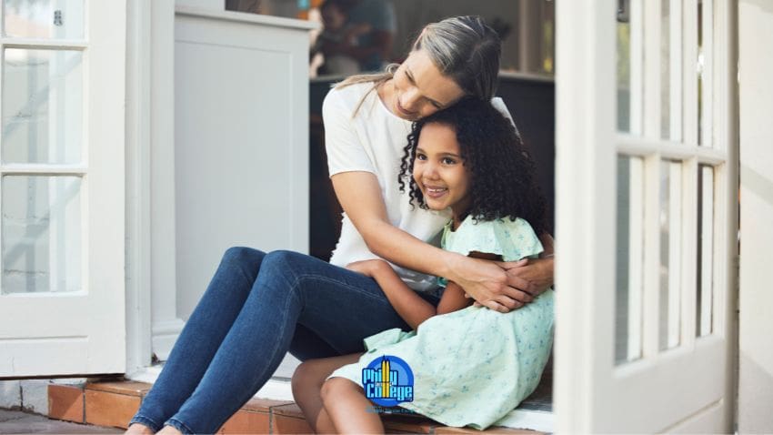 A parent and child sitting on the porch of their home.