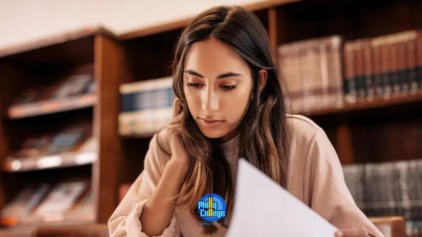 a person is looking at a piece of paper while sitting in a library