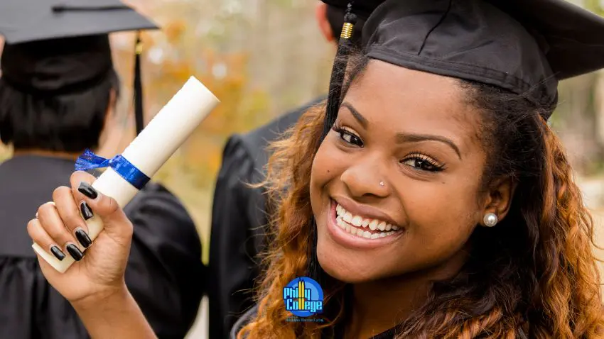 A woman in a graduation gown holding up her diploma