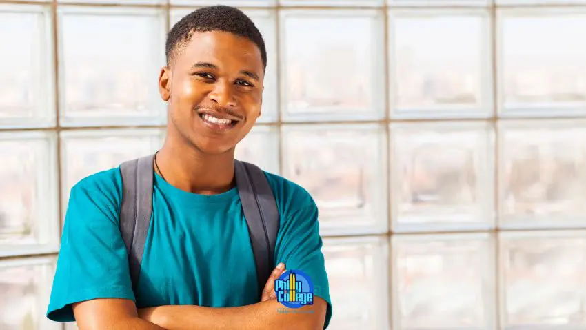 A man with his arms crossed standing in front of a window