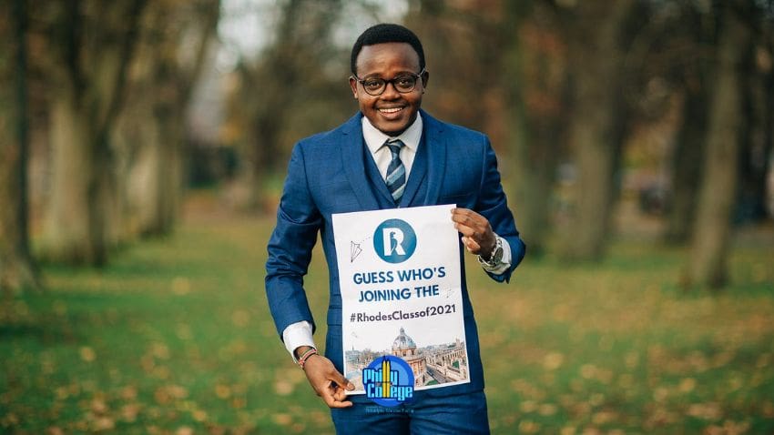 a person in a suit holding a sign in a park
