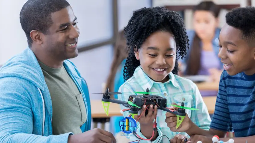 A smiling adult and two children examine a drone they are building together.