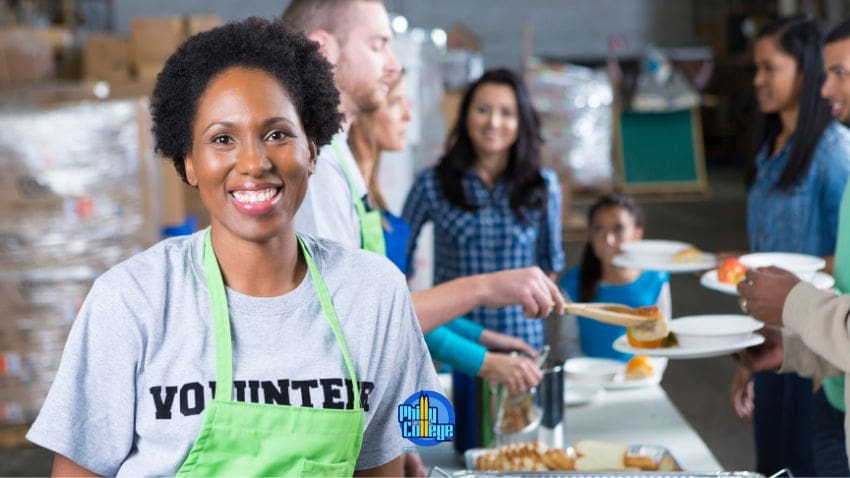 Woman wearing a "volunteer" shirt with a green apron