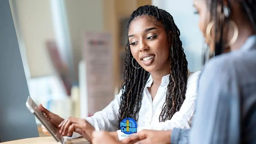Two people at a table looking at a tablet device together.