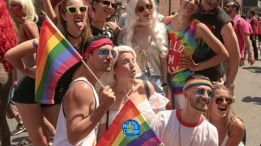 a group of people holding rainbow flags in a parade