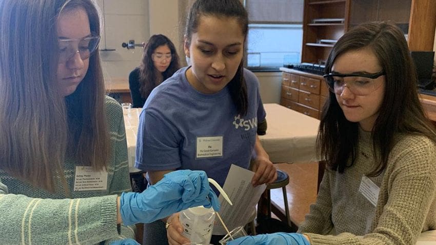 female students conducting experiment in class