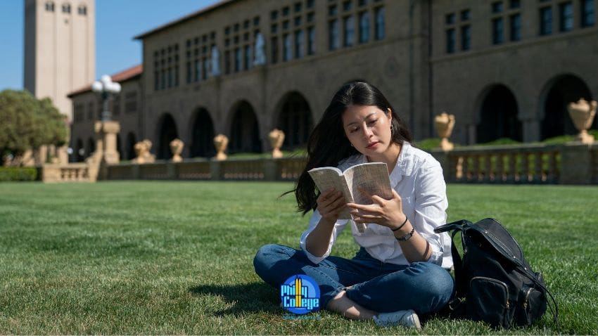 A person sitting on the grass reading a book